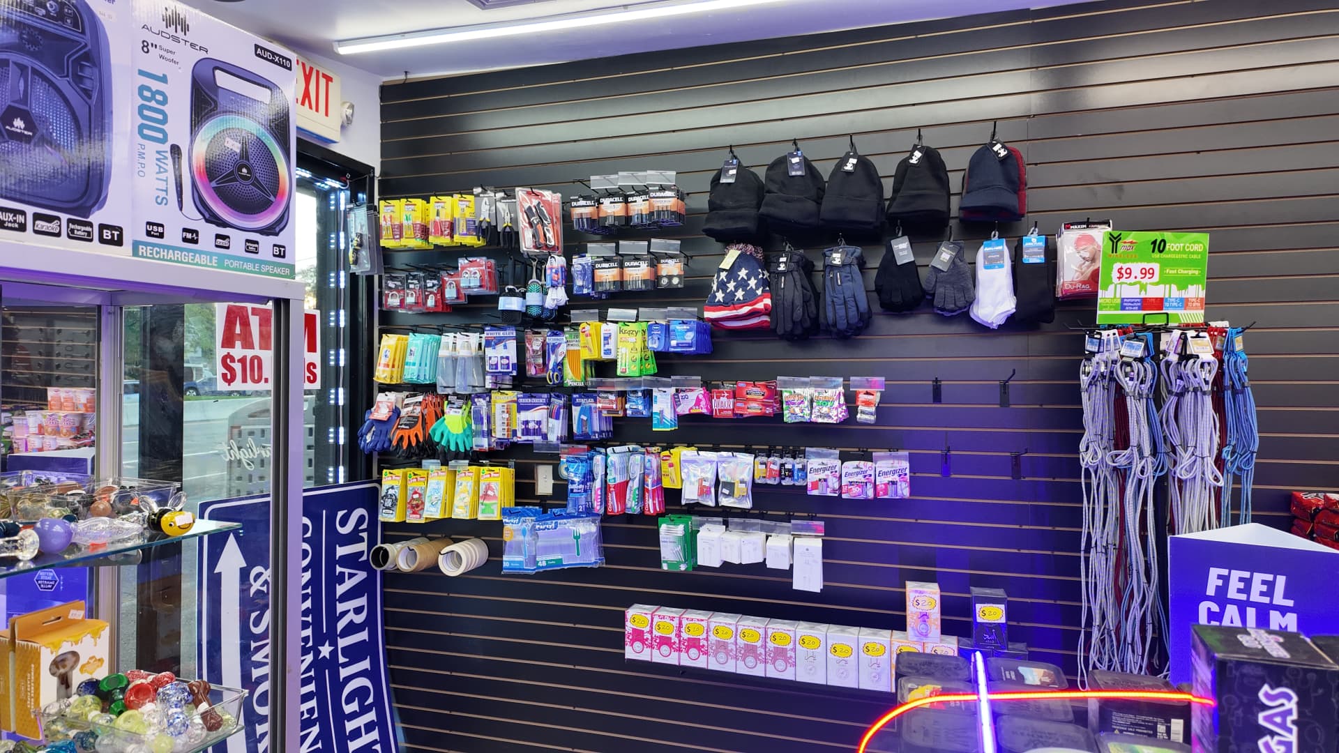 Wall of everyday essentials: batteries, chargers, gloves, hats and household basics