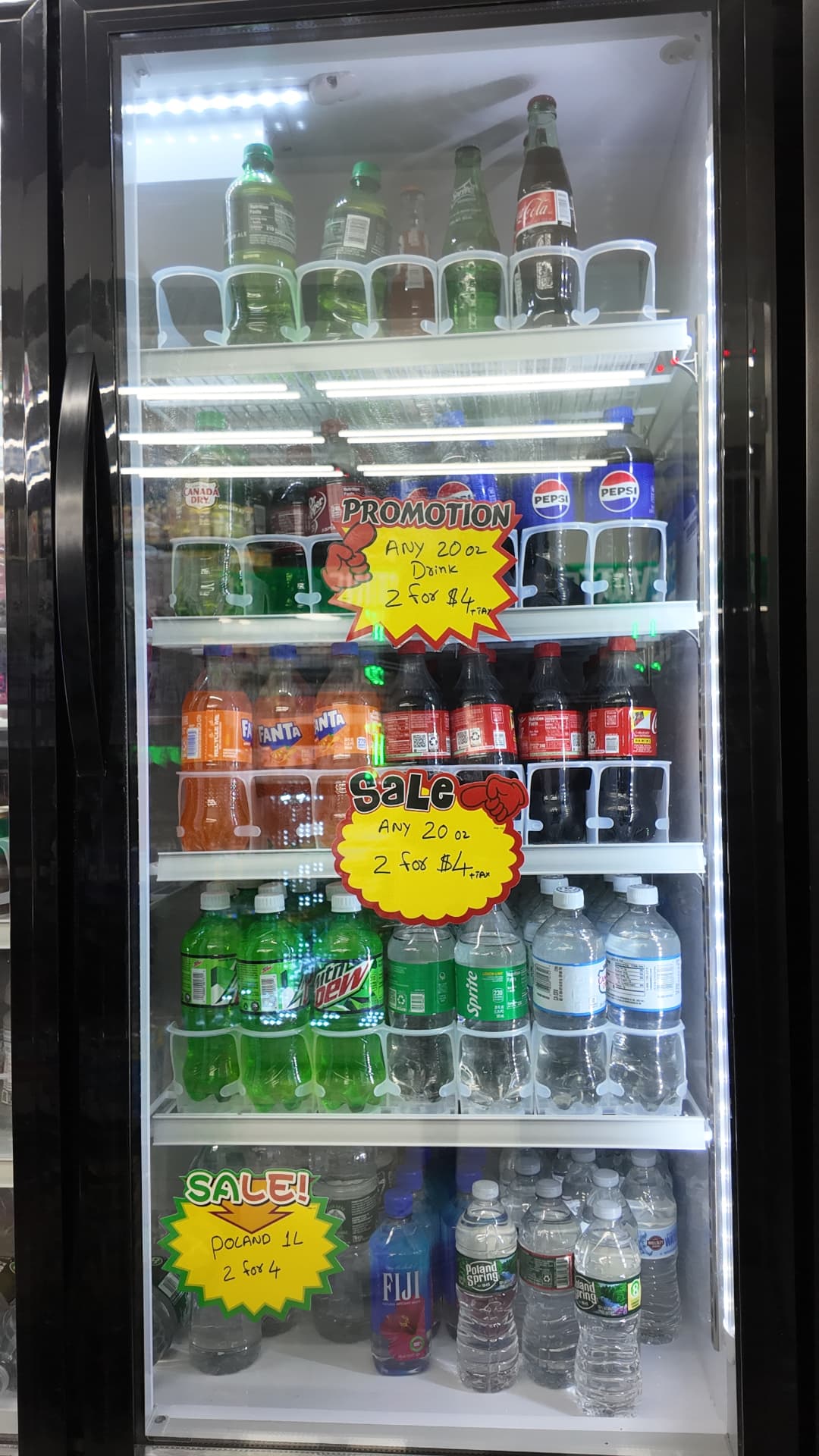Cooler door of 20 oz sodas with 2 for $4 sale signs