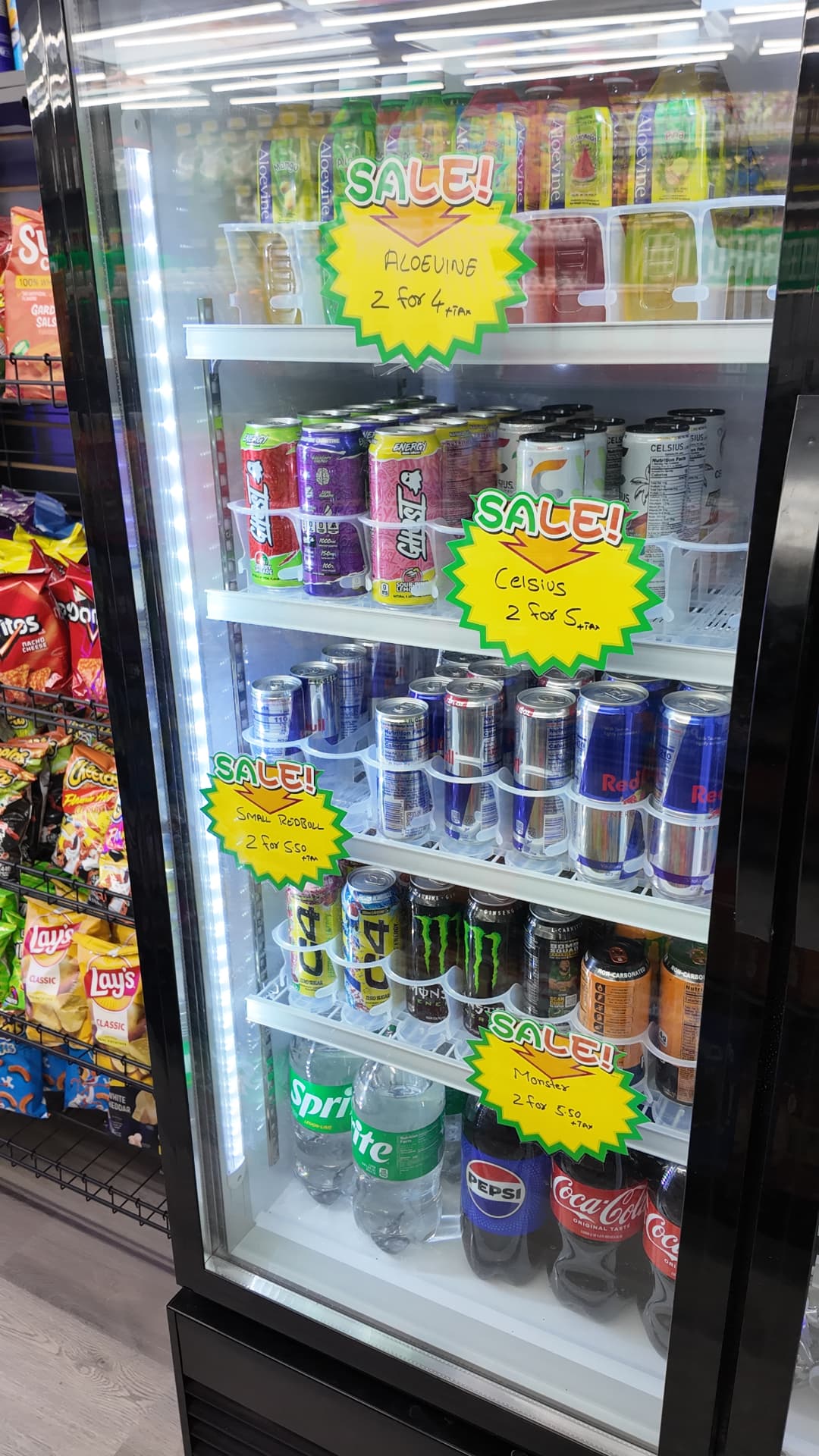 Energy drink cooler with Celsius, Red Bull and Monster deals beside the snack aisle